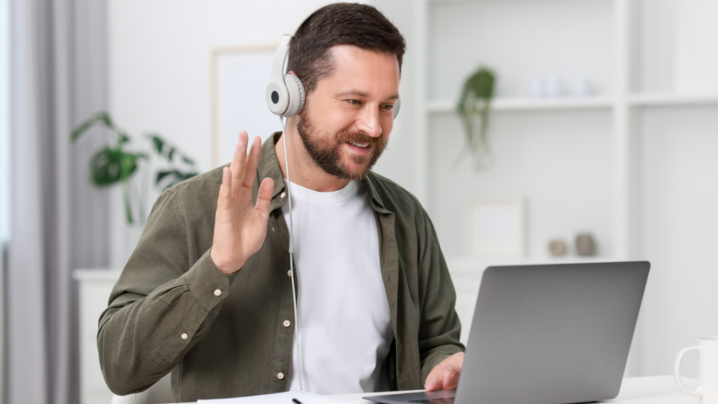 Person using video remote interpreting (VRI) on a laptop to communicate with an interpreter remotely.
